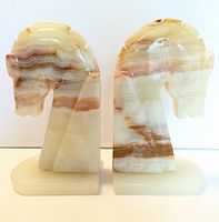 Front view of the two onyx horse head bookends showing color patterns and overall shape.