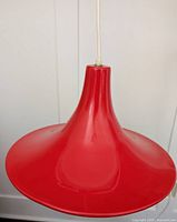 Close-up of red tulip lamp shade showing its shape and glossy finish.