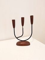 Front view of three-arm mid century candelabra showing teak base, brass arms, and wooden candle holders