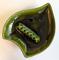 Top view of green glazed ashtray, showing interior and cigarette rest grooves.