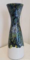 Tall narrow West German pottery vase with flared top and colorful glaze, standing upright