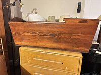 Side view of the antique wooden cradle showing the natural wood grain and classic shape