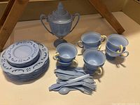Light blue plastic baby’s tea set with cups, saucers, plates, teapot, and plastic cutlery