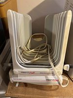 Front view of the Presto Pride electric bread slicer showing the main body, bread holding structure, and coiled power cord inside.