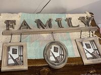 Front view of the wooden family photo frame with three hanging picture slots and the word FAMILY spelled in large wooden block letters.