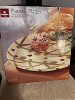 Boxed Stokes Enoteca Holiday Celebrations ceramic platter showing holiday-themed gold, red, and green decorative design.