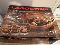 Closed box of Lagostina 3.5L clay roaster with images and text indicating uses: roast, stew, bake.
