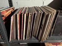 Metal shelves filled with rows of vinyl records showing a mix of album spine labels and cover edges.