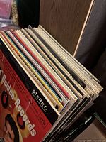 Side view of the stacked vinyl records showing the variety of album spines and different colored sleeves.