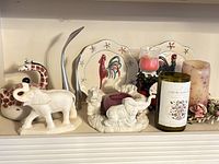 Overview of all animal-themed decorative items including giraffe teapot, elephant figurines, ceramic rooster plates, and decorative candles.