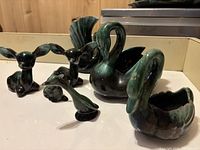 Blue Mountain Pottery animal figurines including swans, deer, and birds on white surface