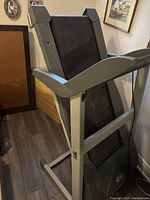 Side view of folded treadmill showing gray frame and running deck