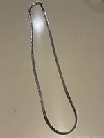 Full view of silver tone textured square link necklace chain showing length and clasp.