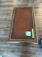 Top view showing the rectangular coffee table with brown leather inlay and decorative gold border on the tabletop.