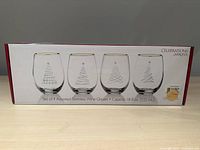Box front showing set of 4 assorted Mikasa Celebrations stemless wine glasses with gold rim and holiday tree designs.