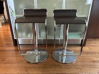 Front view of both barstools showing seat shape and round bases