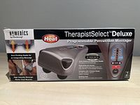 Front view of the box showing the product name, images of the massager, and key features such as dual pivoting heads, high intensity massage for tired muscles, foam cushioned grip handle, multiple massage functions, and heat settings.