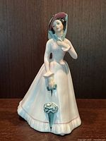 Full front view of Royal Doulton Julia HN2706 figurine, showing the woman in bonnet holding an umbrella