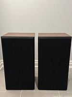 Pair of vintage Aurex Excalibur CS-840 speakers with black front grilles intact, wood finish cabinets, rectangular shape, standing side by side.