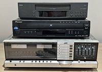 Stack of three components: RCA VCR on top, Pioneer Blu-ray player in middle, JVC JR-S201 receiver on bottom