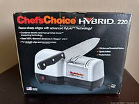 Front of the product box showing the Chef's Choice Hybrid 220 electric knife sharpener with branding and product highlights.