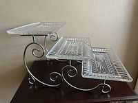 Side view of the elegant 3-tier serving tray showing the rectangular cut glass trays supported by metal frame with scrolling detailing.