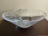 Side view showing the shallow wide design with etched swirling leaf pattern on clear crystal.