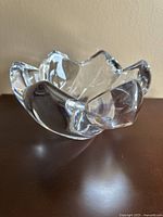 Angled side view of the clear crystal Mikasa Crocus bowl showing petal-shaped edges and thickness of crystal.