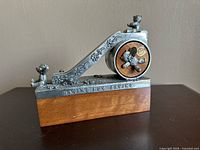 Front view showing bear figurines, floral pewter decorations, and wooden base with inscription 'HAVING FUN SAVING'