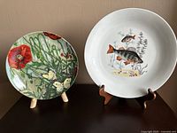 Two decorative plates displayed side by side, showing full front view and designs.