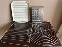 Overview of four items: rectangular wire rack, round pot warmer, utensil holder, and plastic ridged tray.