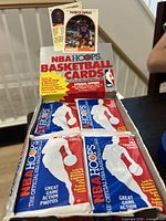 Box of 1989 NBA Hoops basketball cards with four unopened packs, featuring Patrick Ewing card on display.