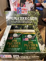Open box displaying multiple sealed packs of 1991 PGA Tour Cards with PGA Tour and Pro Set branding.