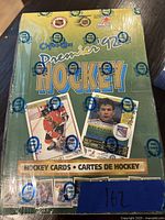 Photo of the top of the sealed 1992 OPC Premier Hockey wax box with OPC branded seal tape, showing vibrant green and gold design with hockey players and cards.