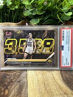 Front side of Caitlin Clark rookie card with scoring record text and Iowa logo in PSA graded case.