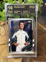 Front view of George Russell 2021 Topps Chrome F1 rookie card graded GEM MINT 10 by FCG with subgrades listed.