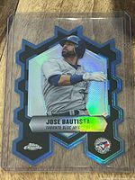 Front of a 2013 Topps Chrome die cut baseball card featuring Jose Bautista in Toronto Blue Jays uniform, with holographic chrome finish and die cut star shape.