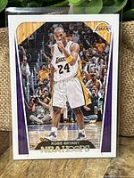 Front side of 2018 NBA Hoops Kobe Bryant basketball card showing player in action wearing Lakers jersey number 24.