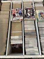 Photo showing multiple stacks of sports cards with Mike Trout and Rafael Devers cards on top.