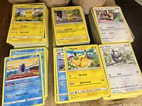 Six stacks of assorted Pokémon cards with Pikachu and Eevee on top