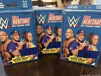 Three sealed boxes of Topps WWE Heritage 2017 trading cards featuring John Cena tribute cards, each box containing 32 cards.