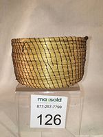 Front-side view of the basket showing the pine needle coiling and black spiral stitching detail.