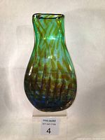 Full front view of the large blown glass vase showing teal blue color, green lattice cane, and Bullicante bubbles.