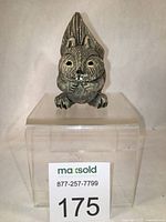 Squirrel figurine displayed on transparent block, showing overall front view.