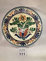 Full view of vintage Korond terra cotta ceramic plate with floral pattern and decorative border.