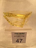 Photo showing angled side view of yellow crystal box with lid on, highlighting thickness and faceted edges.