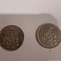 Reverse side of both coins showing the Canadian coat of arms and year dates 1972 and 1973.