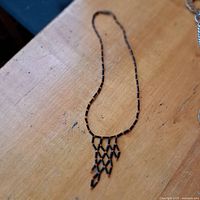 Black and orange beaded necklace laid flat on wood surface