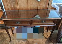 Front view of Gibbard wooden sofa table with glass top and two drawers on cabriole legs, showing minor wear.