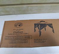 Box for Hampton Bay 10x10 foot Chatham gazebo showing branding, dimensions and specifications including double tiered roof and mesh mosquito netting.